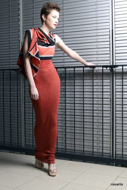 DSC 7804 Večerky- s pruhovaným oranžovo-černým topem Originální model večerních šatů vytvořených pro přehlídku Prague Fashion Week. Model je pletený ze čtyř barev-černá+oranžová +červená stříbrná, luxusní efektní příze Jafar, ve složení: 93% viskóza +7% lamé/ se stříbrnou nitkou/. Horní část pruhovaného kimonového topu s třemi otvory pro ruce je zavinovací jako šál, s možností spustit zavinutí a odhalit záda, spodní část je oranžový/s lamé / žebrový úplet- tunika./údržba- ruční praní do 30st. ŠATY JSOU VELMI DLOUHÉ A NEJDOU ZRÁTIT, DÉLKA NA MODELKU.   Originální model večerních šatů vytvořených pro přehlídku Prague Fashion Week. Model je pletený ze čtyř barev-černá+oranžová +červená stříbrná, luxusní efektní příze Jafar, ve složení: 93% viskóza +7% lamé/ se stříbrnou nitkou/. Horní část pruhovaného kimonového topu s třemi otvory pro ruce je zavinovací jako šál, s možností spustit zavinutí a odhalit záda, spodní část je oranžový/s lamé / žebrový úplet- tunika./údržba- ruční praní do 30st. ŠATY JSOU VELMI DLOUHÉ A NEJDOU ZRÁTIT, DÉLKA NA MODELKU.  